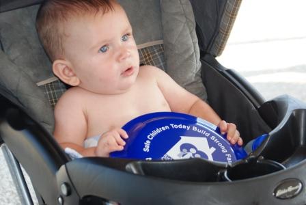 A smiling baby holds onto a Richland County Children Services frisbee during Family Day at the 2010 Richland County Fair.